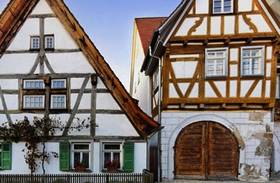 Altes Fachwerkhaus mit einem großen braunen Holztor an der Front.