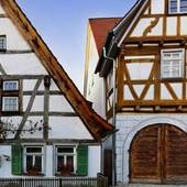 Altes Fachwerkhaus mit einem großen braunen Holztor an der Front.